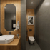 Modernes Badezimmer mit Holzakzenten, ovalem Spiegel, weißem Waschbecken und Toilette.