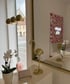 Goldene Flamingo-Statue auf einem weißen Sockel, mit Orchideen und einem Spiegel.