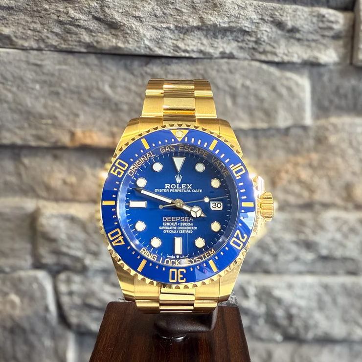 Goldene Rolex Deepsea Uhr mit blauem Zifferblatt und Lünette, darauf "ROLEX DEEPSEA" und "ORIGINAL GAS ESCAPE VALVE" steht.