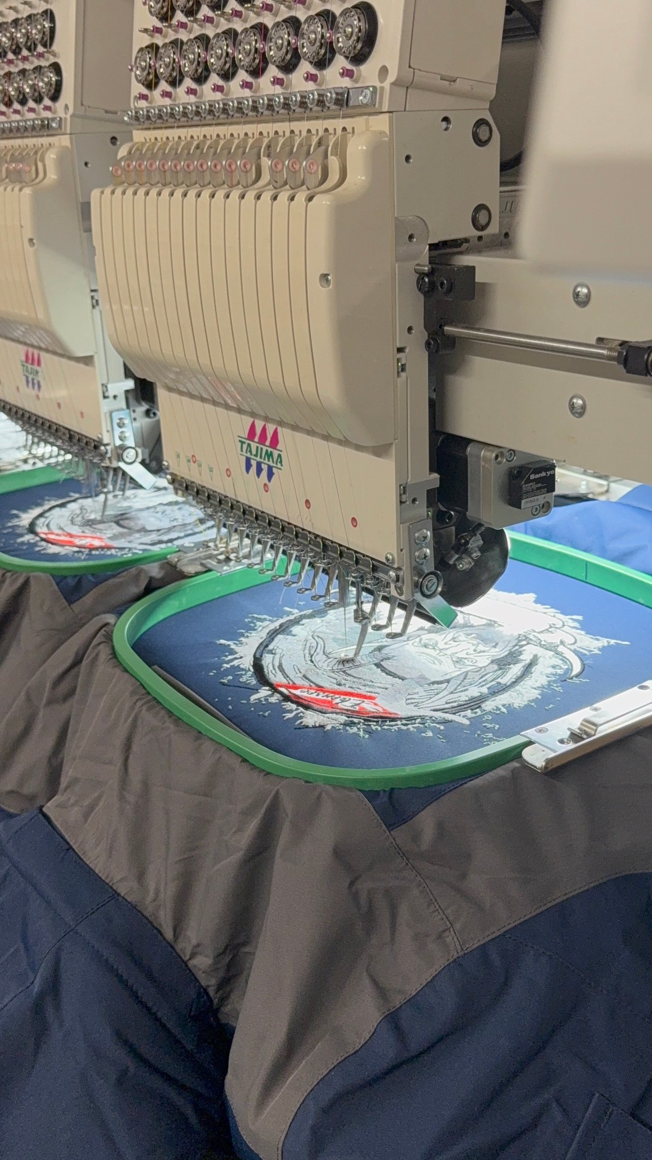 Tajima-Stickmaschine bestickt mehrere blaue Textilien gleichzeitig