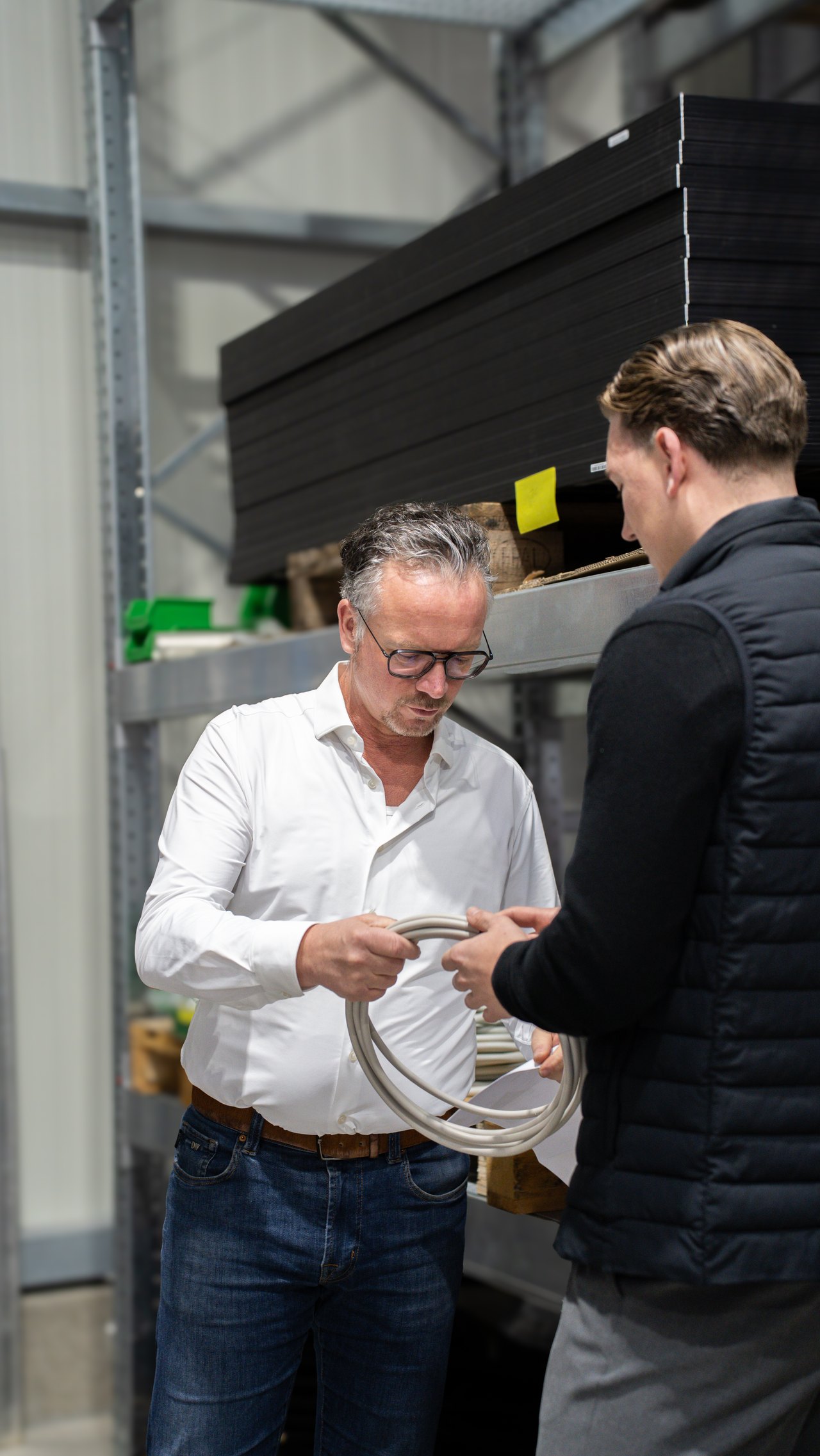 Zwei Mitarbeiter besprechen ein Solarmodul im Lager