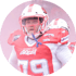 American-Football-Spieler in rotem Trikot mit der Nummer 79 und weißem Helm mit rotem Streifen, im Freien bei Nebel oder Rauch.