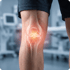 An anatomical overlay of a human knee joint showing a glowing red area of pain or inflammation on the patella and meniscus.