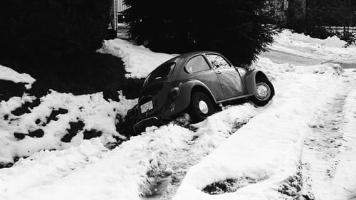Car stuck in snow in a roadside ditch during a central Illinois winter near Normal, IL