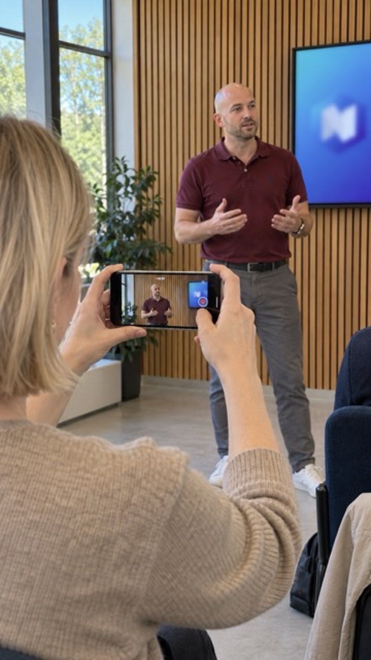 Teilnehmerin filmt einen Trainer beim Vortrag mit dem Smartphone