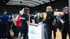 Menschen im Gespräch an einem Messestand der Firma JUNO-BAU in einer gut besuchten Messehalle.