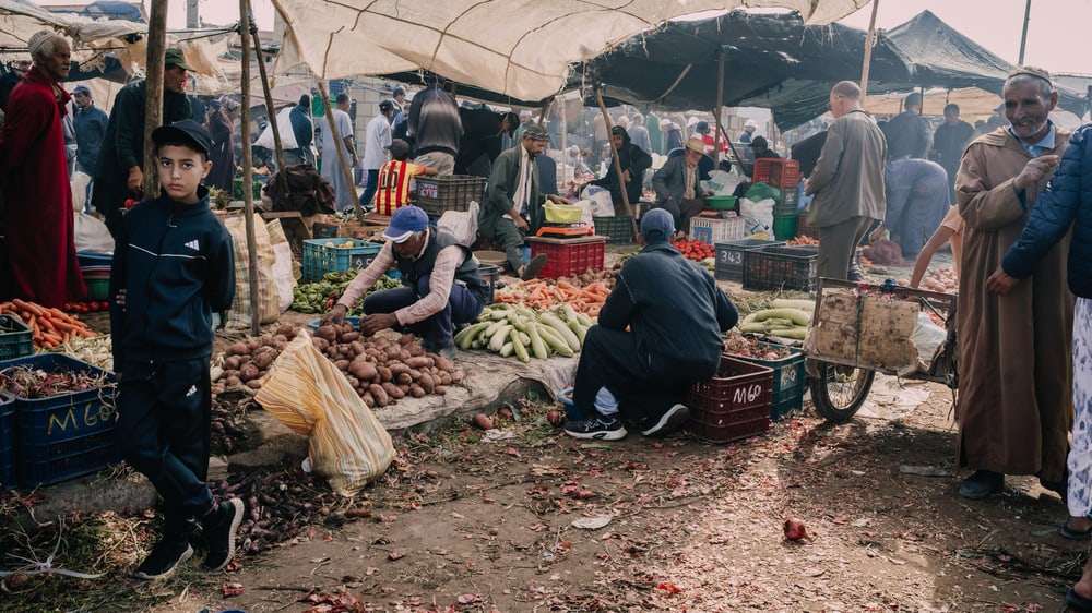 Wochenmarkt mit Gemüsehändlern unter Zeltdächern