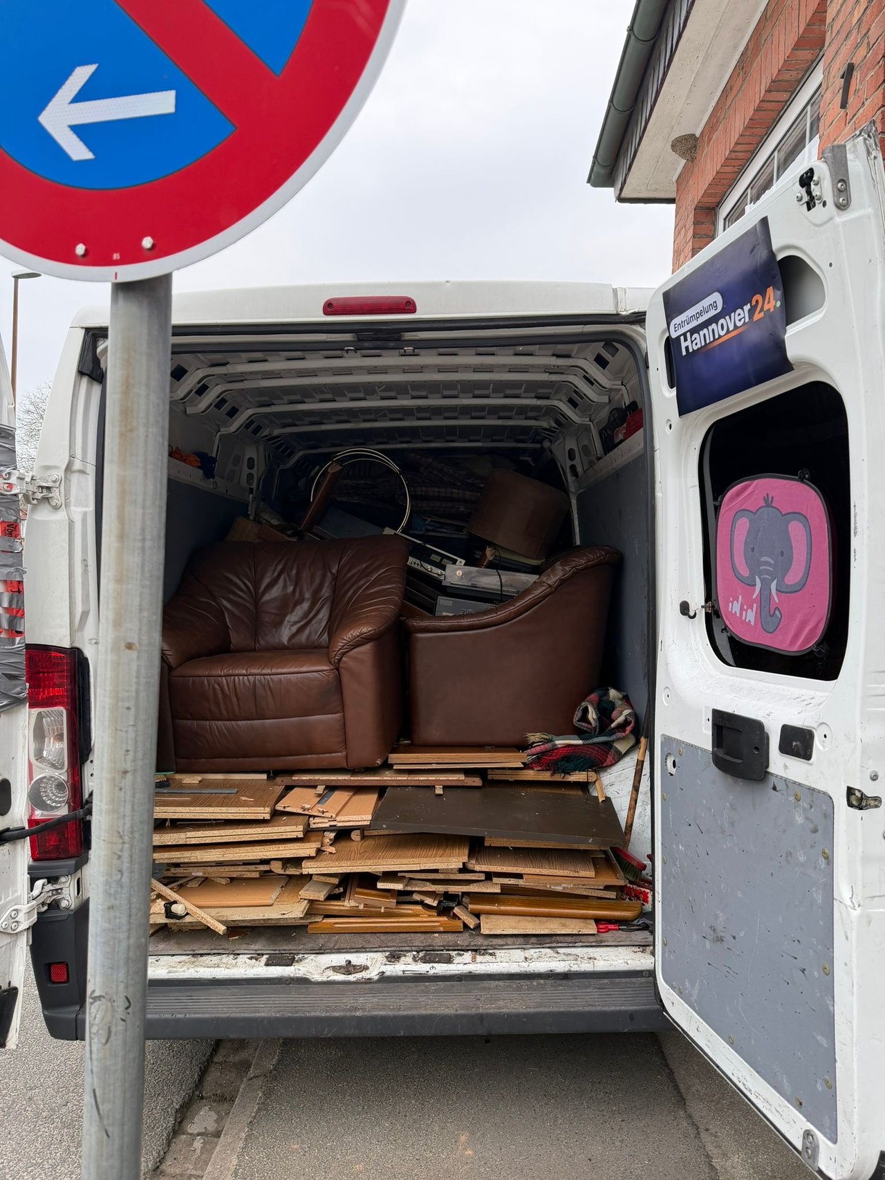 Beladener Transporter mit Firmen-Banner bei einer Entrümpelung