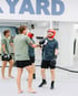 Zwei Männer beim Boxtraining nach dem Sparring vor einem Spiegel im Boxclub unter dem Schriftzug BACKYARD.