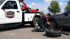 Towing Corona technician performing a flat tire change on a stranded car with roadside assistance equipment.