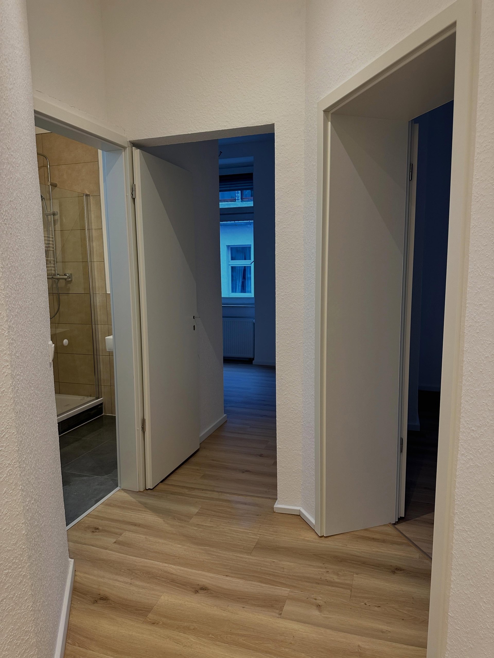 Weiße Türen und Zargen, strukturierte Wände und heller Holzboden
