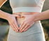 Smiling woman placing hands on her abdomen, highlighting gut health.