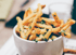 Eine Tasse Pommes frites mit Kräutern bestreut.