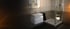 Modernes Badezimmer mit weißem Waschbecken, Spiegelschrank, und Eckduschkabine.
