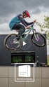 Ein Mountainbiker springt mit seinem Fahrrad über eine Küchenzeile.