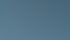 Wärmepumpe auf einer Terrasse vor einem Wohnzimmer mit Sofa und Regalen.