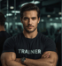 Muskulöser Fitness-Trainer mit verschränkten Armen und T-Shirt mit der Aufschrift „TRAINER“.