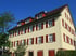 Seitenansicht des sanierten Schulhauses mit Gauben und Klappläden