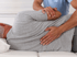 Chiropractor adjusting a patient's back who is lying on their side.