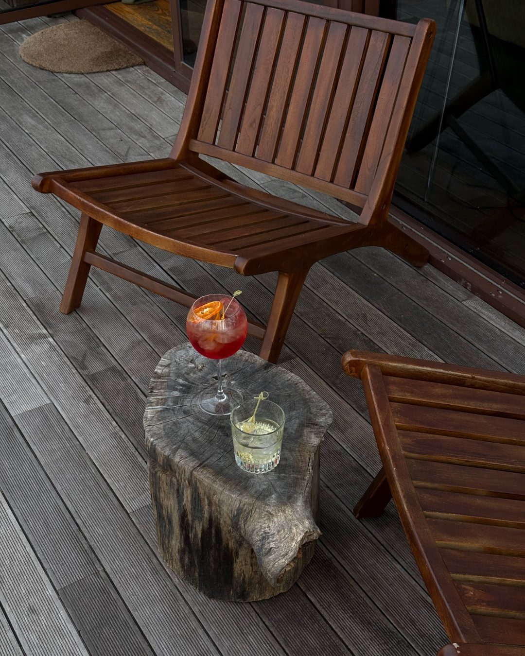 Drinks on a small table between wooden chairs