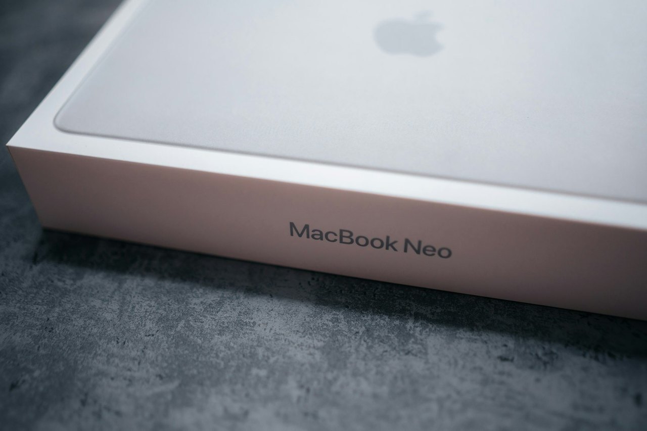 Originalverpacktes MacBook im weißen Apple-Karton auf einem grauen Tisch