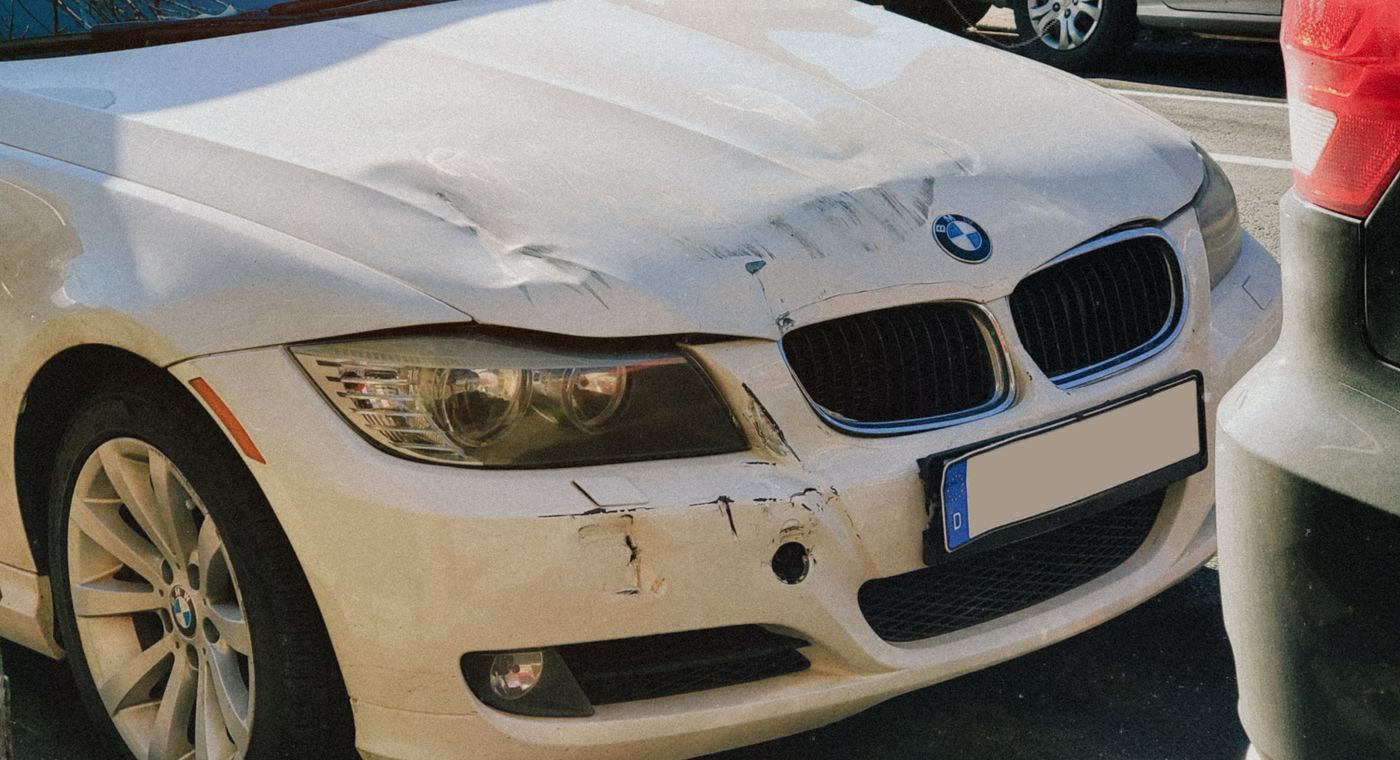 what happens to your car after an accident: a sedan with front-end collision damage on a city street in Orlando, FL
