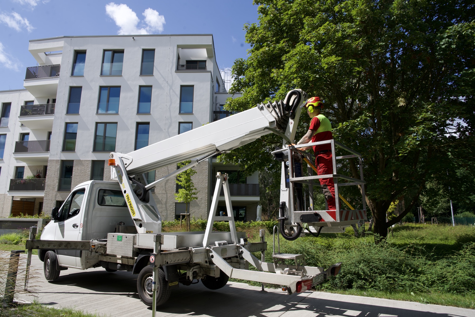 Hubarbeitsbühne aufgebaut vor einer Wohnanlage