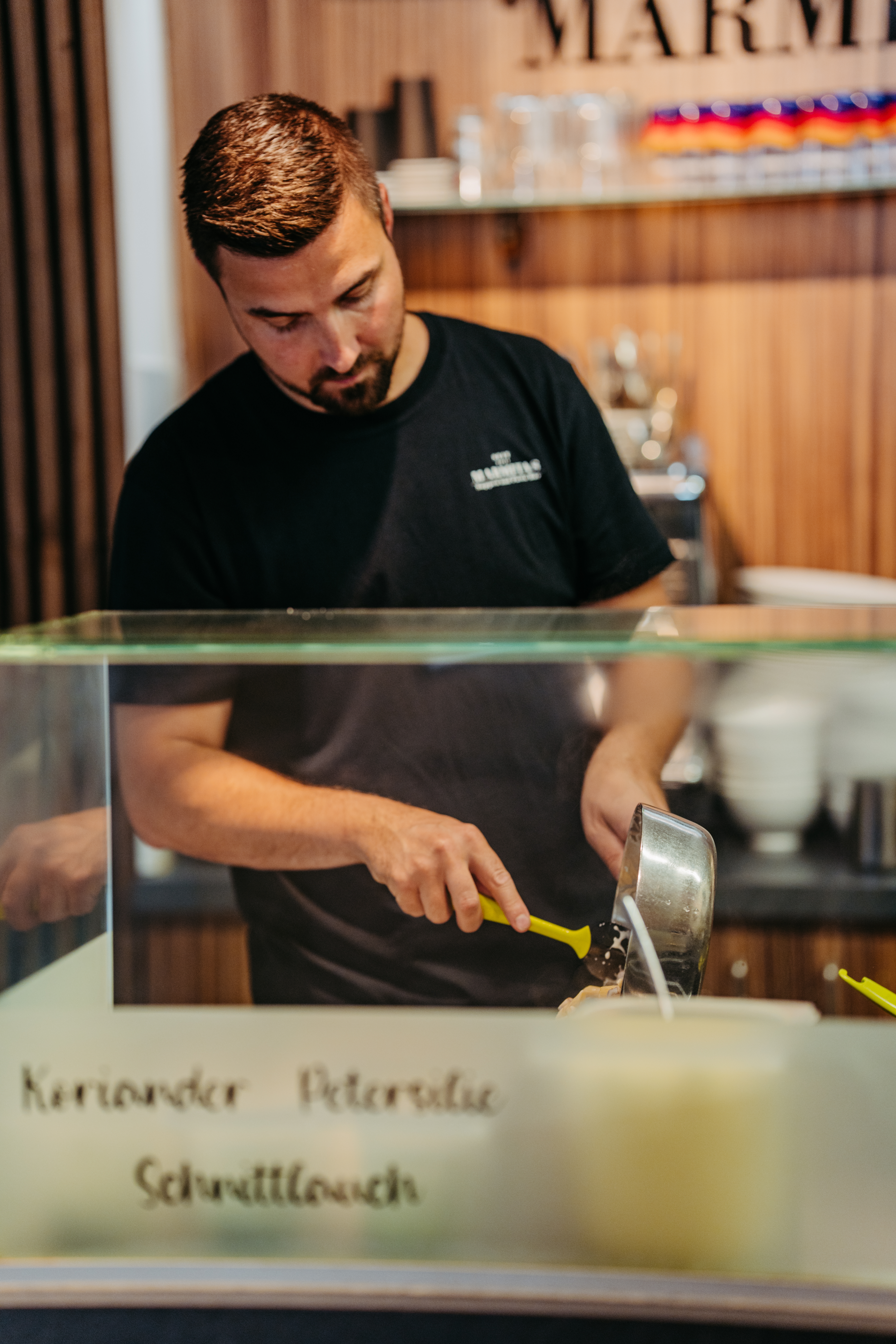 Mitarbeiter bereitet am offenen Frontcooking-Tresen ein Gericht zu