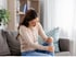 Seated woman experiencing knee pain from a pinched nerve condition