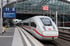 Ein weißer ICE-Zug steht auf einem Bahnsteig unter einem Glasdach; ein blauer Anzeigebildschirm zeigt "11 B München Hbf" - Software-KRITIS Notfall- und Krisenmanager (NKM®).