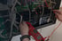 Hände messen mit einem roten Multimeter die Spannung an zwei Q-Batteries Akkus in einer elektrischen Anlage.