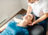 A male chiropractor treating a female patient's neck after a sports injury.