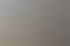 Ein Mann sitzt an einem Schreibtisch vor einem Computer und blickt nach vorne.