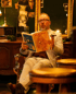 Mann mit Brille und Zigarre liest eine Playboy-Zeitschrift in einem Barbershop.