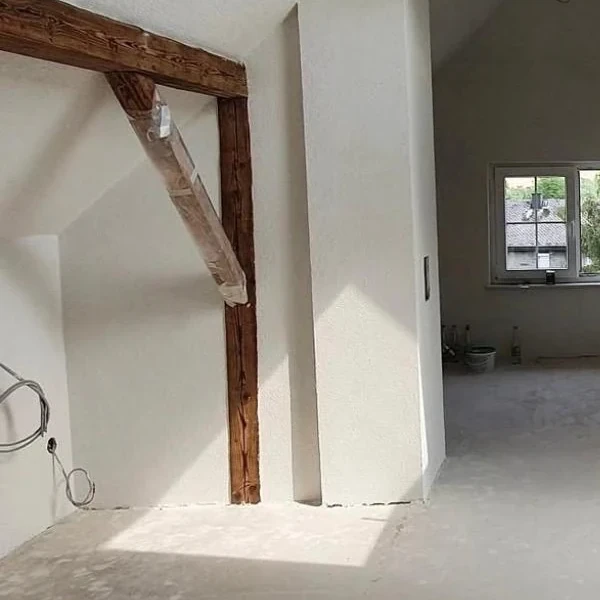 Frisch verputzter Raum mit sichtbarem Deckenbalken