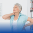 An older woman holding her neck and back.