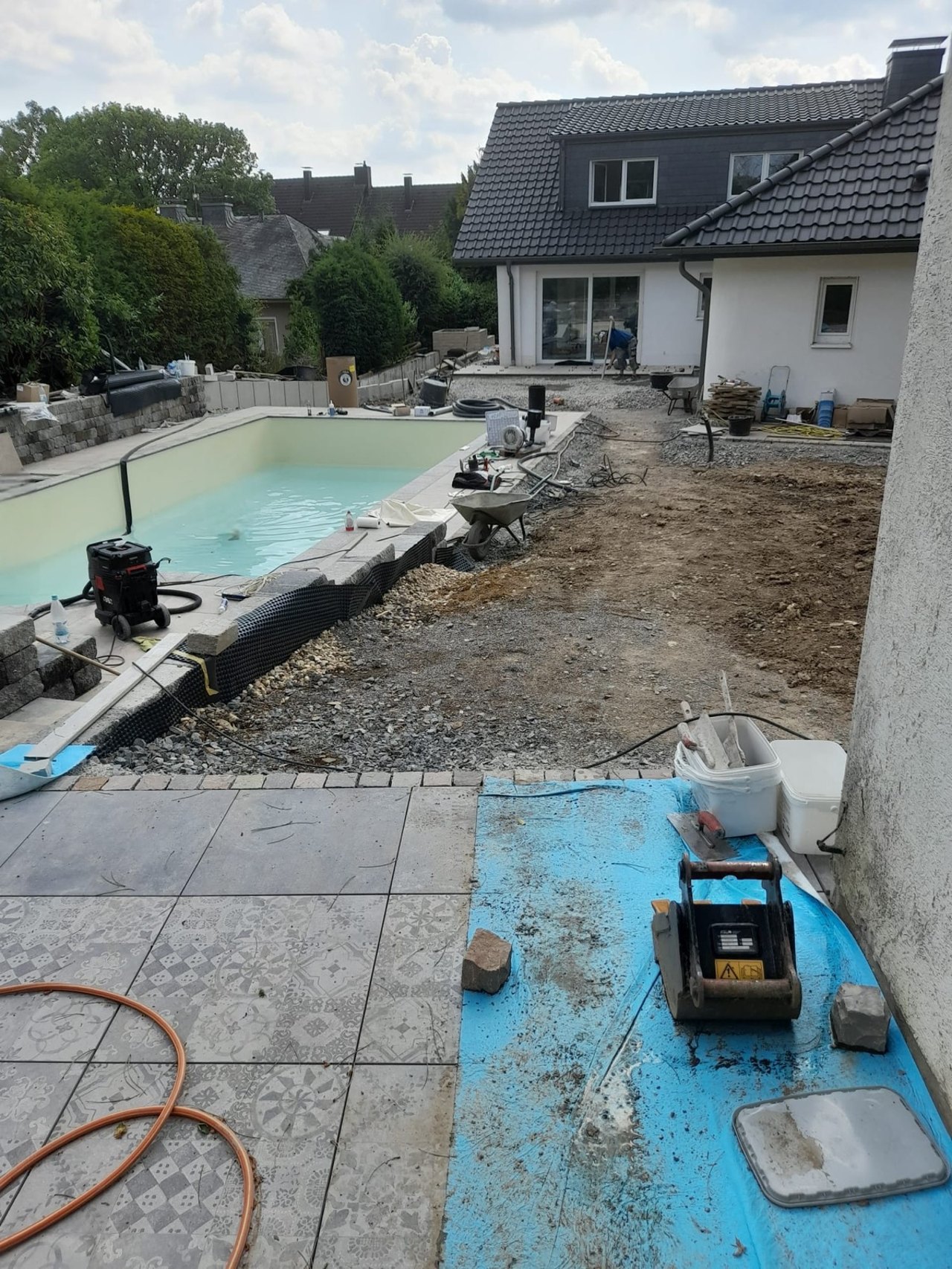 Baustelle der Außenanlage mit Pool und Erdarbeiten