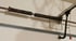 Broken garage door torsion spring on a metal rod above a white garage door.