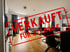 Wohnzimmer mit Holzboden, Sofa, Esstisch und "VERKAUFT FÜR 379.000 €" Stempel.
