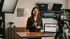 Business-Coachin bei der professionellen Videoaufzeichnung mit Kamera, Softbox und Social-Media-Analyse auf dem Laptop.
