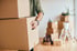 closeup-man-carrying-cardboard-boxes-while-relocating-into-new-apartment