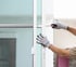 Hausmeister stellt mit Werkzeug Türen und Fenster ein