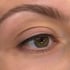 Nahaufnahme eines weiblichen Auges mit brauner Iris und dezentem Eyeliner.