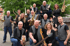 Eine 13-köpfige Liveband mit Blasinstrumenten, Gitarren und Schlagzeug posiert im Freien.