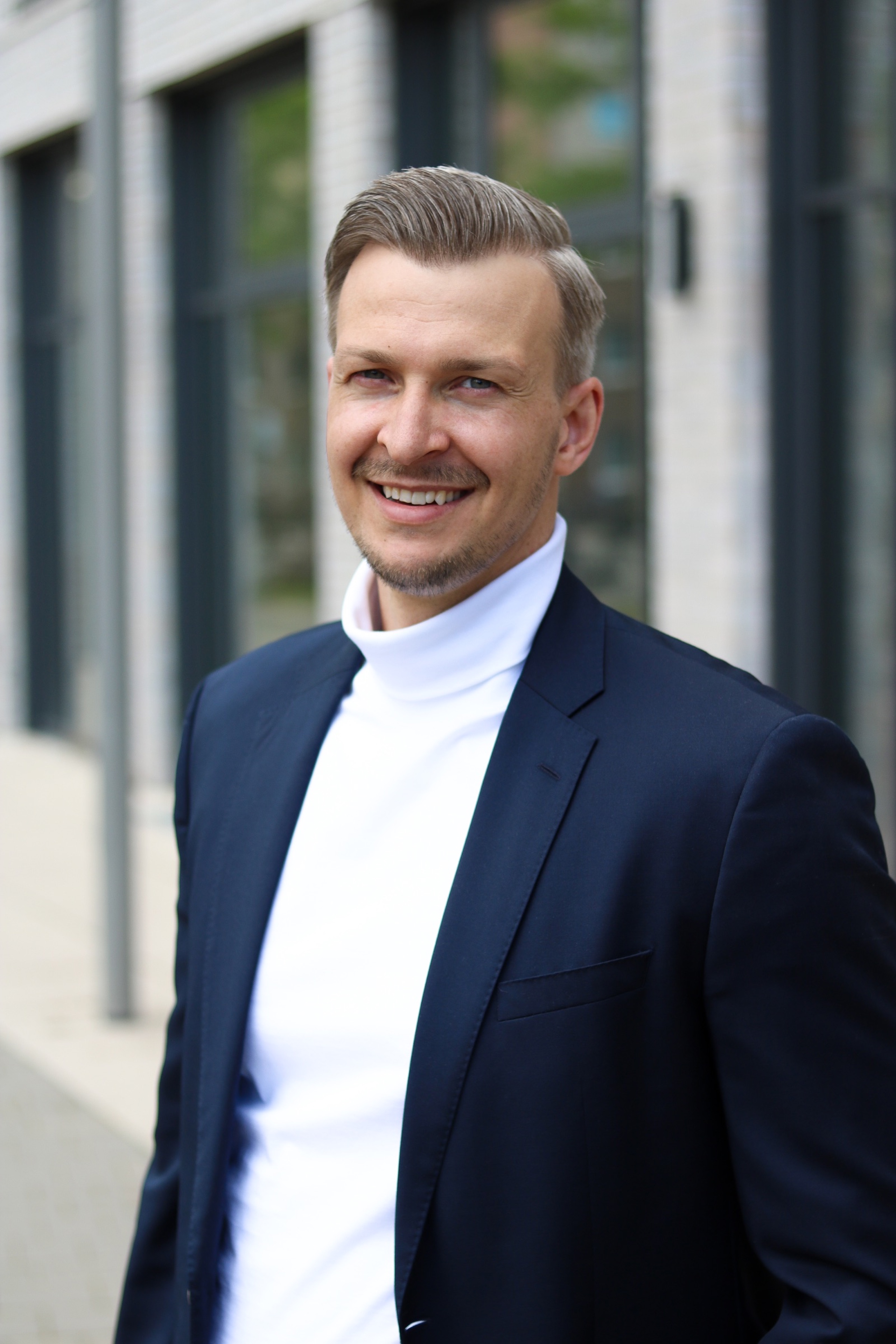 Porträt von Tobias Heuse vor moderner Architektur