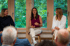 Drei Frauen sitzen bei einer Podiumsdiskussion vor einem Fenster mit Blick ins Grüne und sprechen zu einem Publikum.
