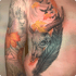Tattoo auf Oberkörper und Arm mit Tierschädel, großer Feder, herbstlichen Ahornblättern, Vögeln und Waldmotiven.