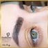 Nahaufnahme einer Frau mit blauen Augen und frisch gestochenen, dunklen Microblading-Augenbrauen.