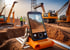 Ein Smartphone auf einem orangefarbenen Ständer nimmt eine Baustelle mit Baggern und Erdhügeln auf.