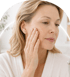 A woman touching crepey skin on her face